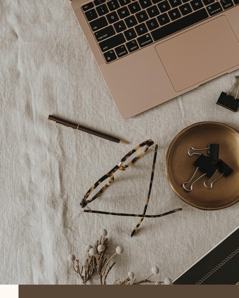 Designer's desk with laptop, notebook and gold accents